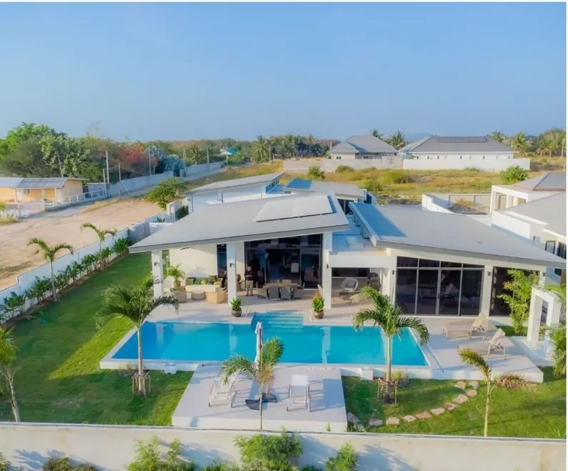 Aerial view of a completed Moda pool villa with garden and neighbouring houses