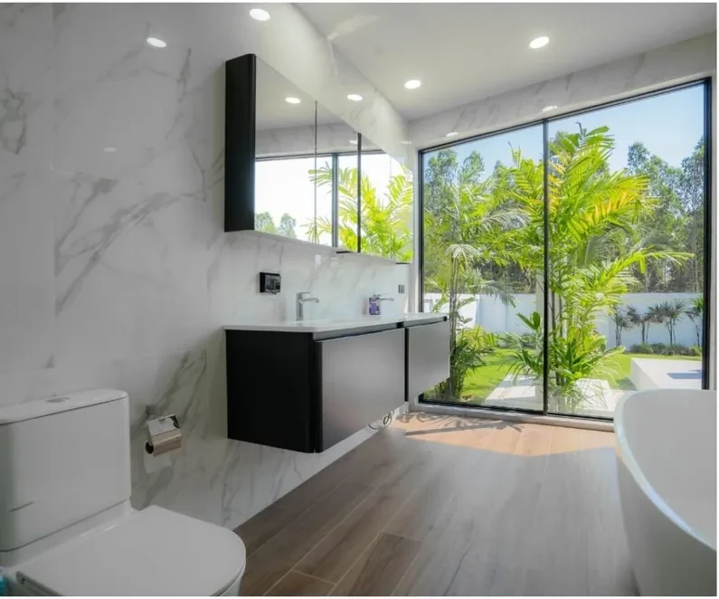 Marble-clad bathroom in a Moda villa with garden view window